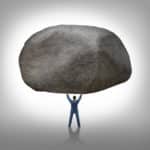 Power of leadership with the ability to inspire as a businessman lifting up a huge boulder removing a large obstacle and leading by example as a business concept of success and determination.